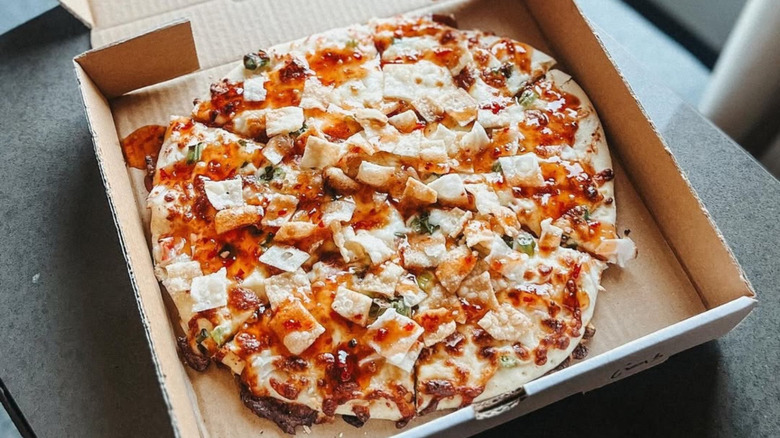 Fong's Pizza's crab rangoon pie in a pizza box, loaded with toppings and sauce