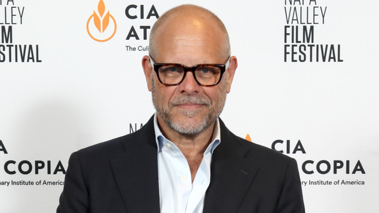 Alton Brown wearing a white collared shirt, a black blazer, and glasses at a film festival