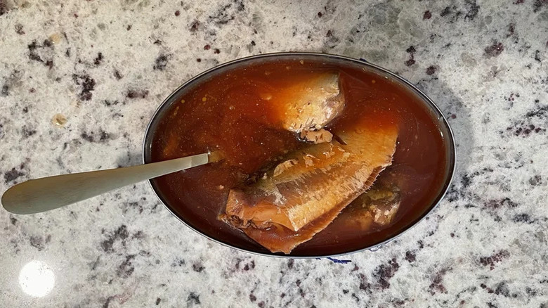 An open can of Goya sardines in tomato sauce with a spoon