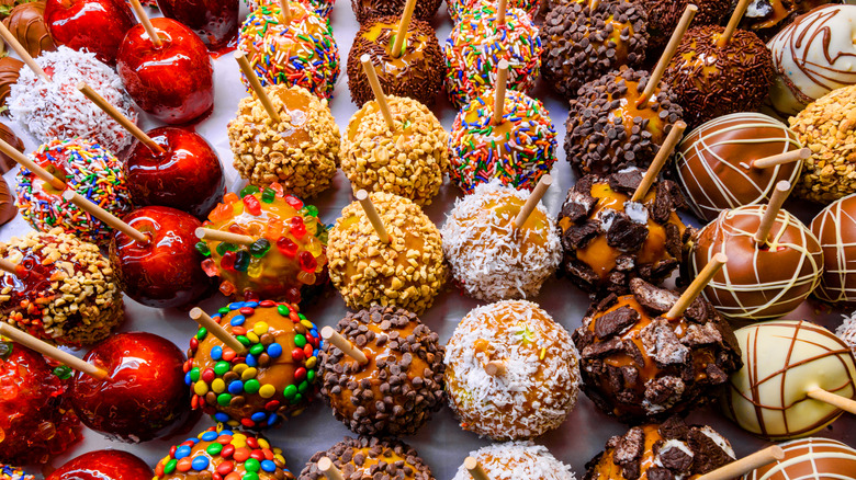 Variety of candy apples dipped in different coatings and toppings