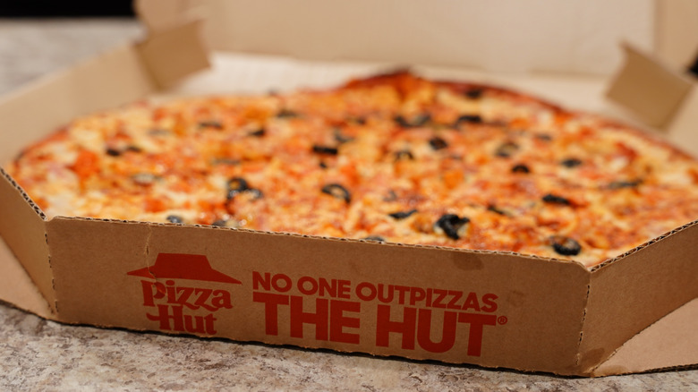 Pizza Hut delivery box open with pizza inside.