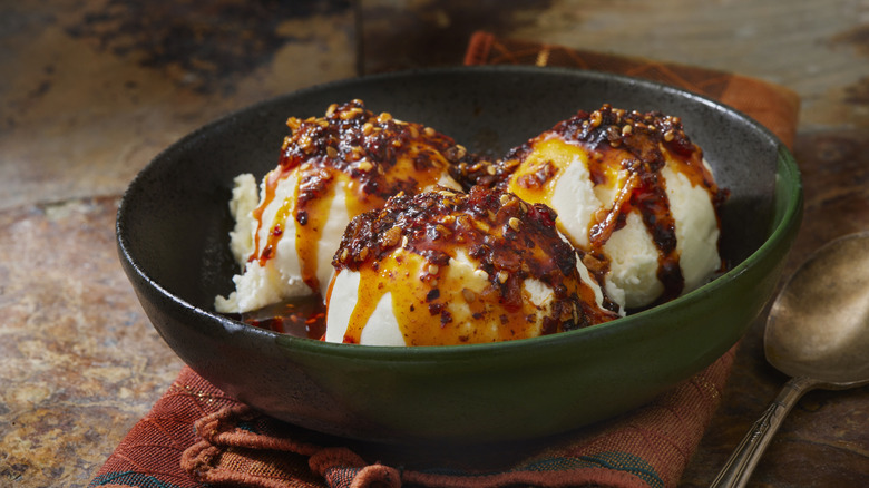 Chili crisp-topped ice cream in dark green bowl