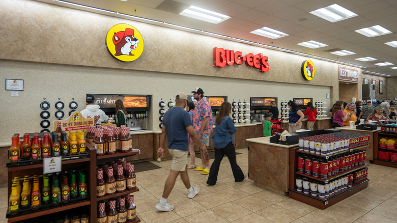 People standing at and walking past soda fountains inside a Buc-ee's