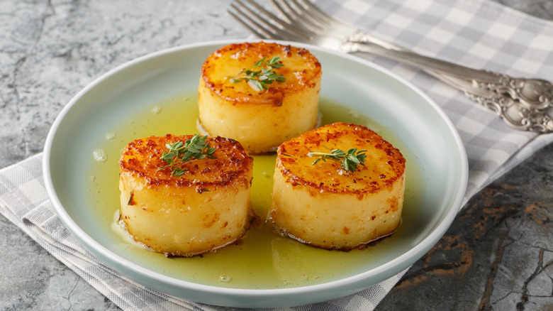 Garlic thyme melting potatoes on a green ceramic plate