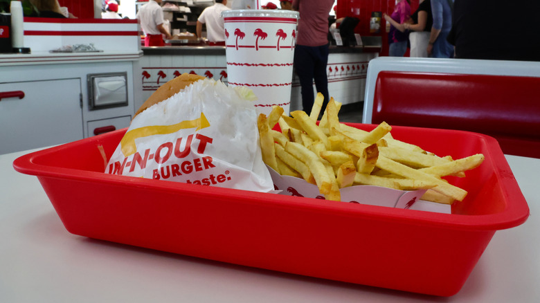 A red tray holding a burger, fries, and a drink at In-N-Out