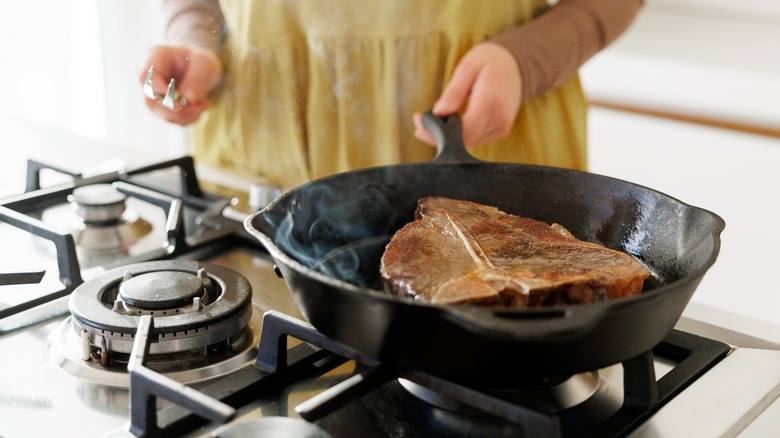 Person cooking in cast iron pan