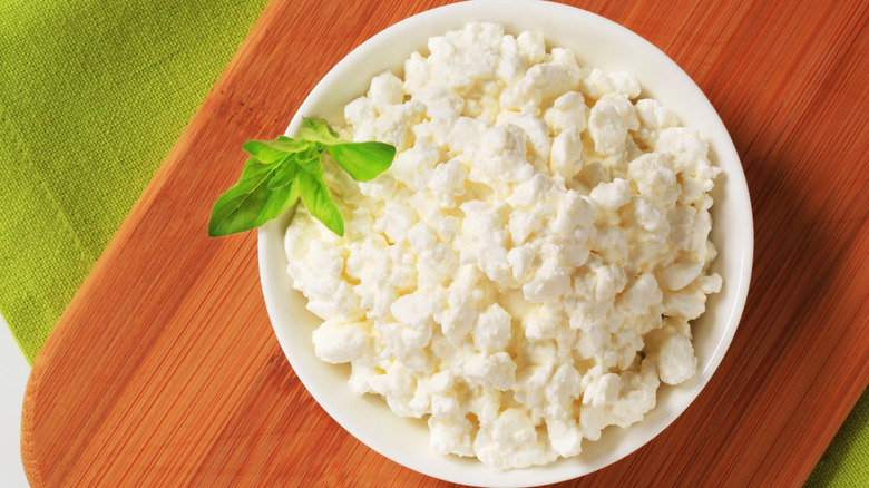 Bowl of cottage cheese garnished with a fresh herb