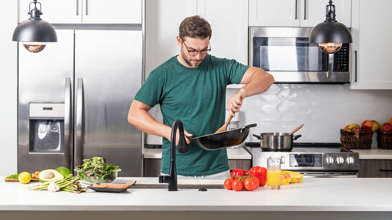 A person cooks in a home kitchen.
