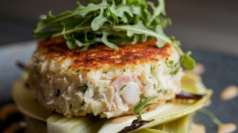 A large, golden crab cake in close-up.