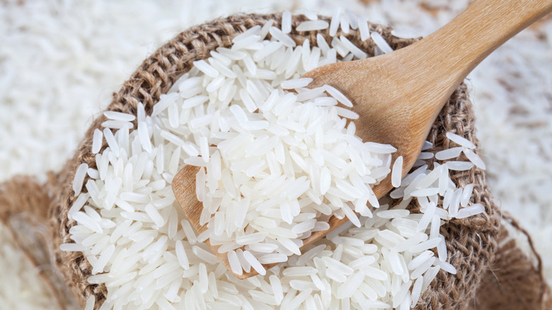Raw rice grains wood spoon