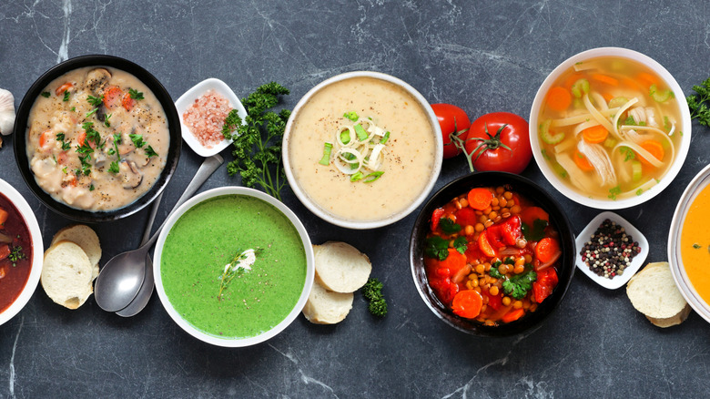 An assortment of small bowls of soup displayed on a countertop