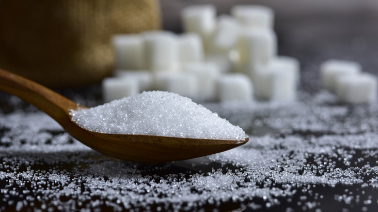 White sugar on wooden spoon