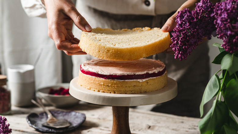 A chef assembling a layer cake.