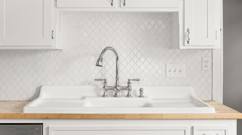 white vintage style sink in an all white kitchen