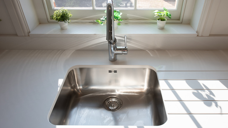 stainless steel sink set in a white countertop