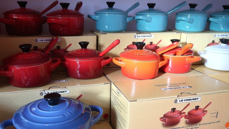 Colorful Le Creuset Dutch ovens stacked on Le Creuset product boxes