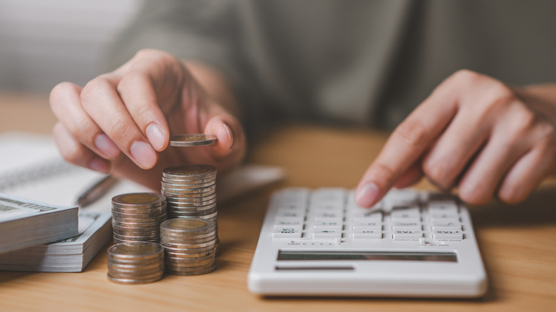 hand counting money with calculator