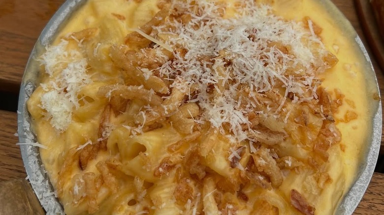 A close-up view of BrewDog mac and cheese with shredded cheese added on top for the final touch