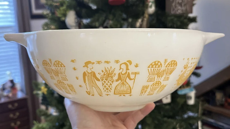 A rare Pyrex pumpkin butterprint bowl is held by a hand