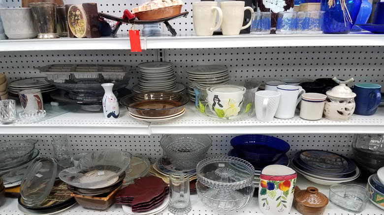 Shelves of dishware at a thrift store.