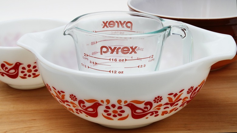 A Pyrex casserole with a Pyrex measuring jug inside