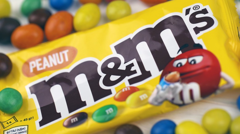 Package of Peanut M&M's surrounded by various colors of Peanut M&M's candies