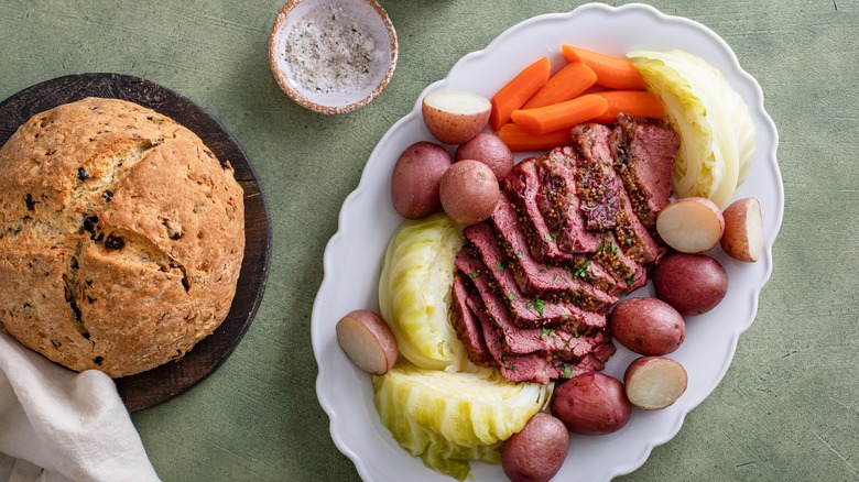 Irish soda bread and dish of corned beef, cabbage, potatoes, and carrots