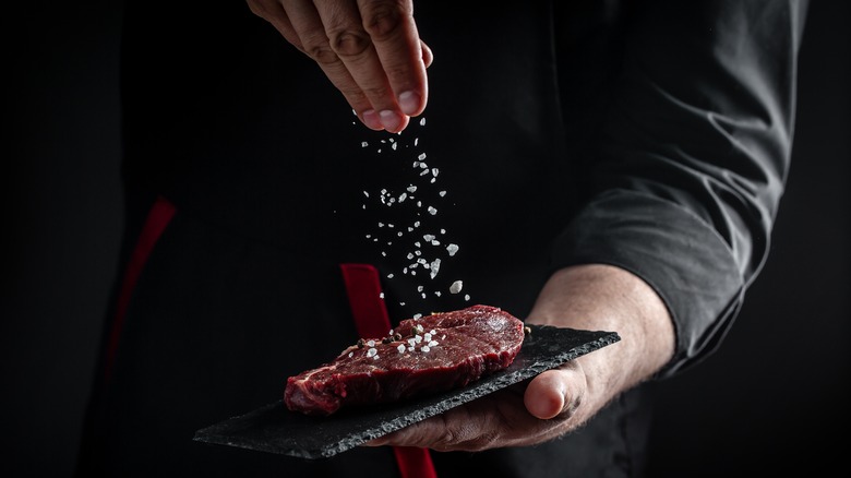 Chef seasoning a steak