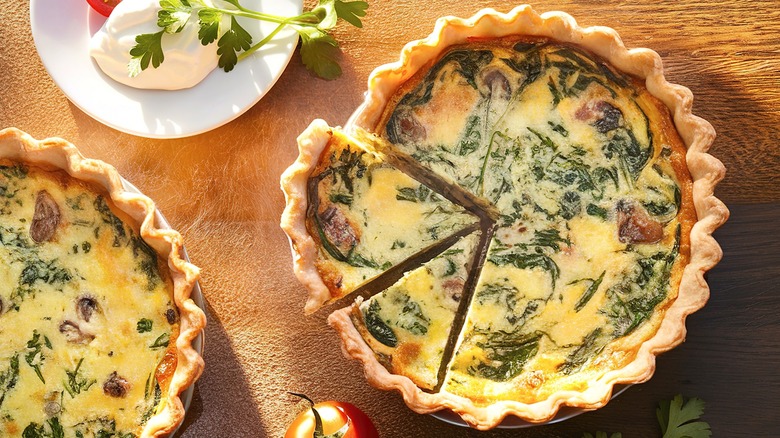 dua quiches bayam dikelilingi oleh tomat dan burrata