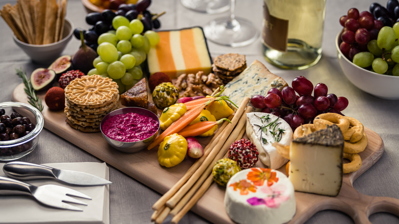 Charcuterie board with striped cheese, grapes, and figs