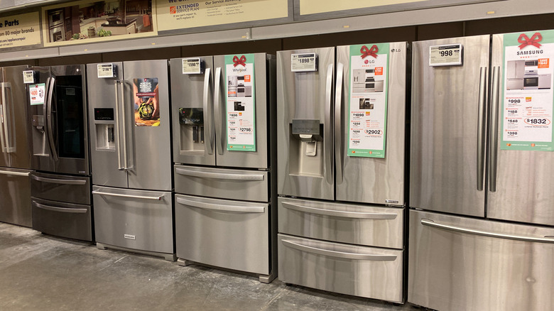 A row of stainless steel French door refrigerators at a store