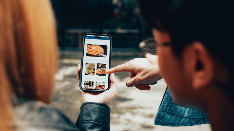 Couple scrolling through a digital menu on a phone