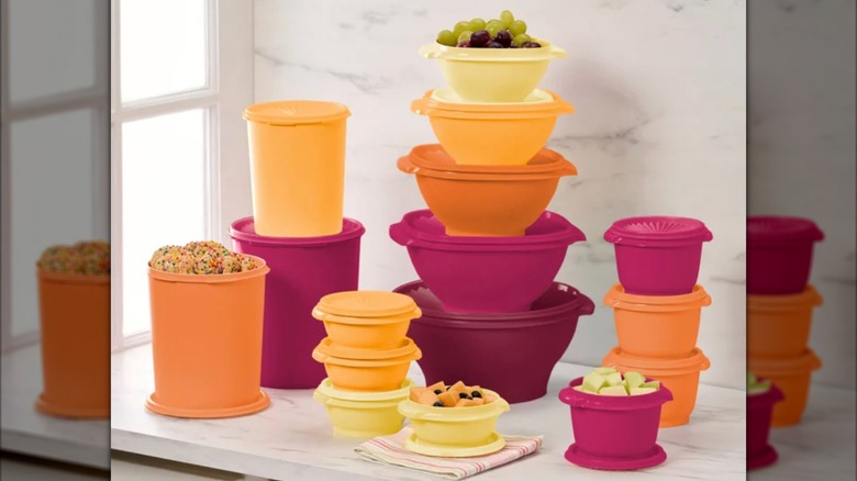 Tupperware Heritage Collection containers and lids in yellow, orange, and pink on a kitchen counter