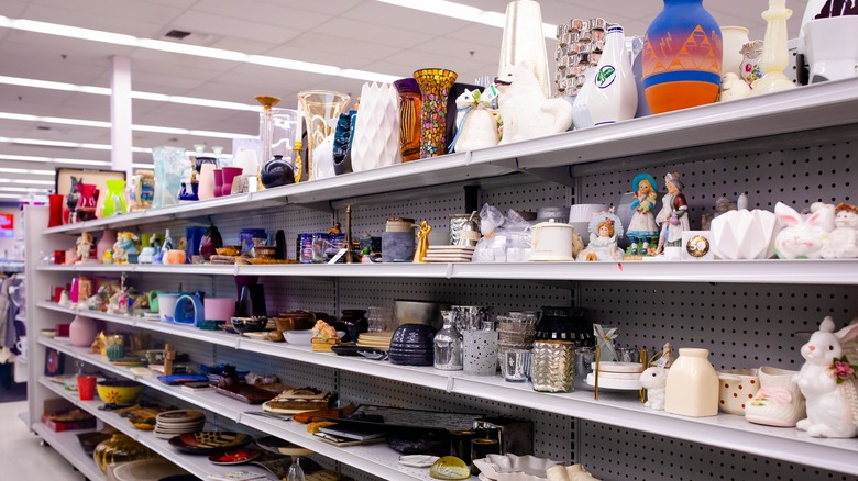 A thrift shore's shelves are lined with tons of ceramic kitchen items and figurines.
