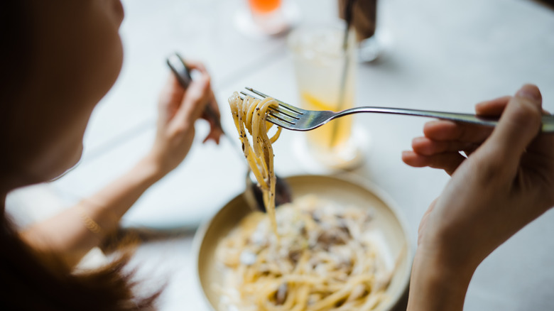 a woman eating spaghetti