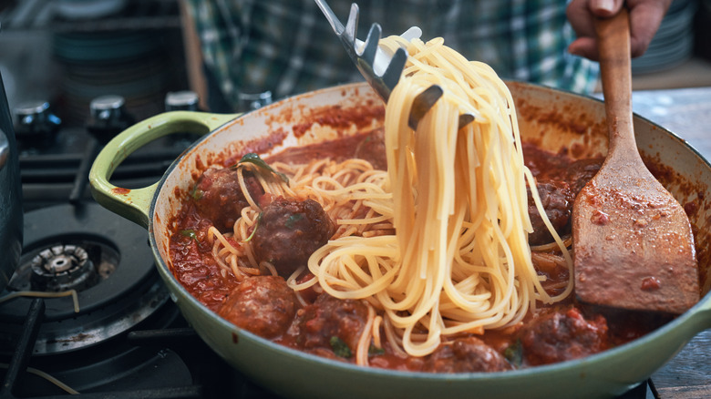 Spaghetti in pan of sauce
