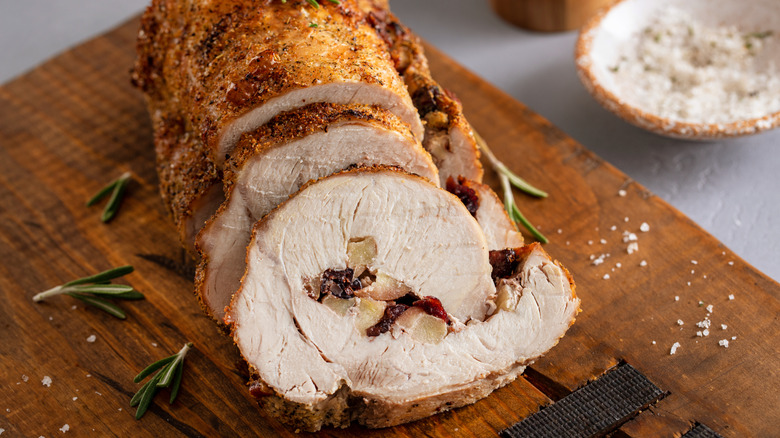 sliced pork tenderloin on a wooden cutting board