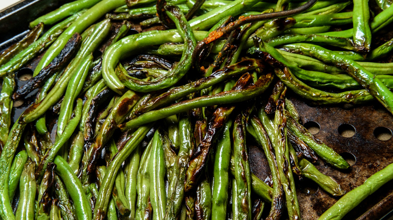 Roasted, semi-charred green beans fresh out of the oven, cooling on a cookie sheet