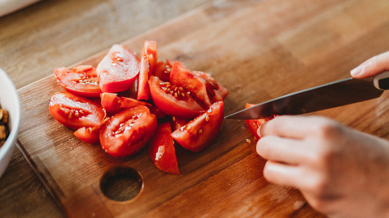 Cutting tomatoes on cutting board