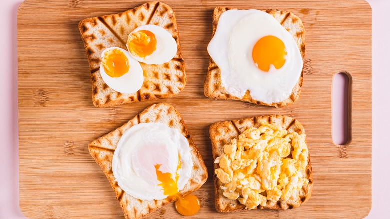 variously cooked eggs on a wooden cutting board