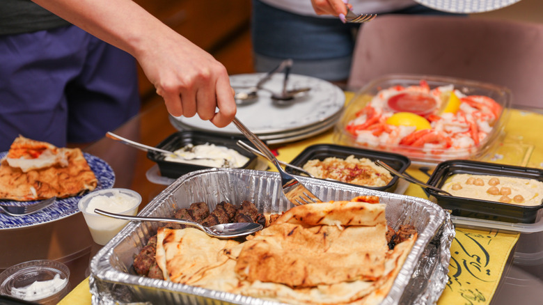 food at potluck in disposable containers