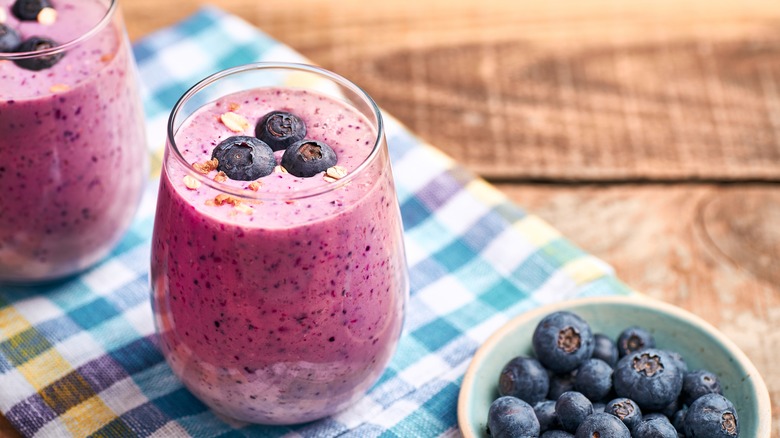 Blueberry smoothies on plaid wood background.