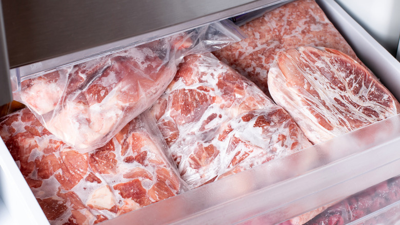Wrapped frozen meats in freezer drawer.