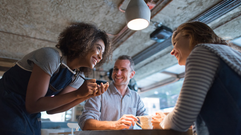 Woman taking order from couple