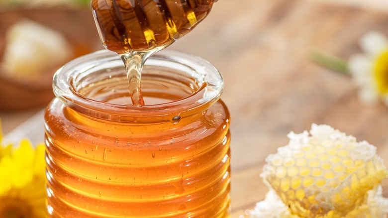 Jar of honey with honeyycomb