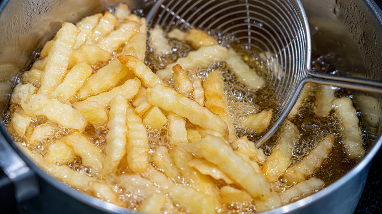 French fries frying in oil in a pot