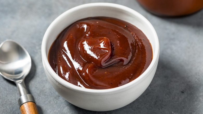 A small white bowl of barbecue sauce.