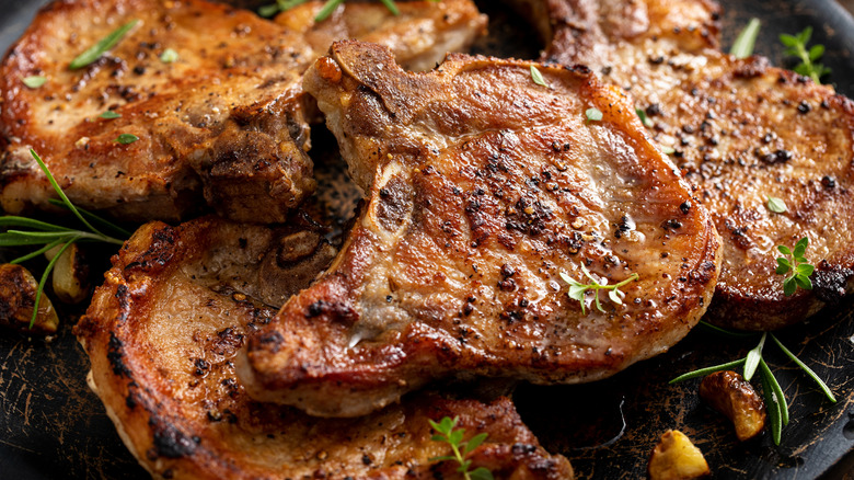 bone-in pork chops with herbs in a cast iron pan