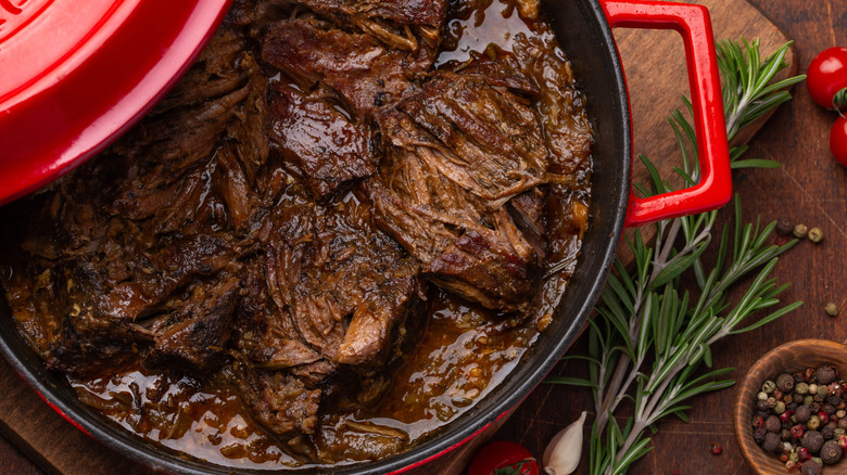 A saucy, tender meat inside a red slow cooker