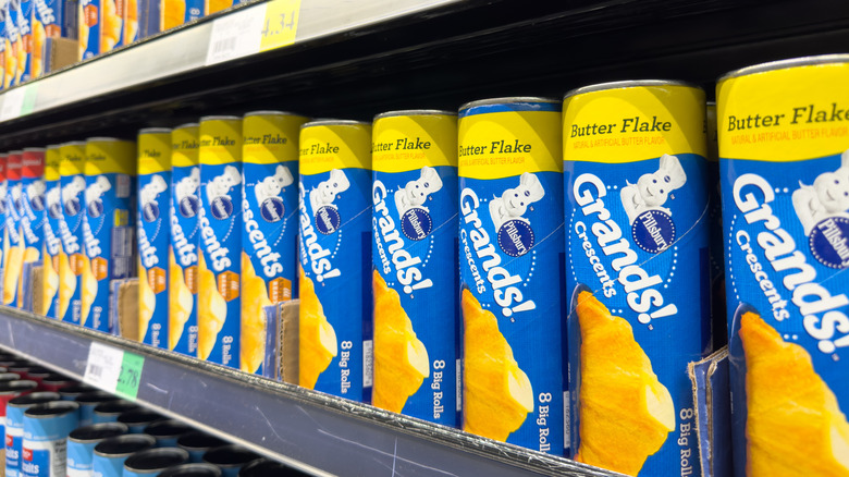 A grocery store shelf of canned biscuit dough